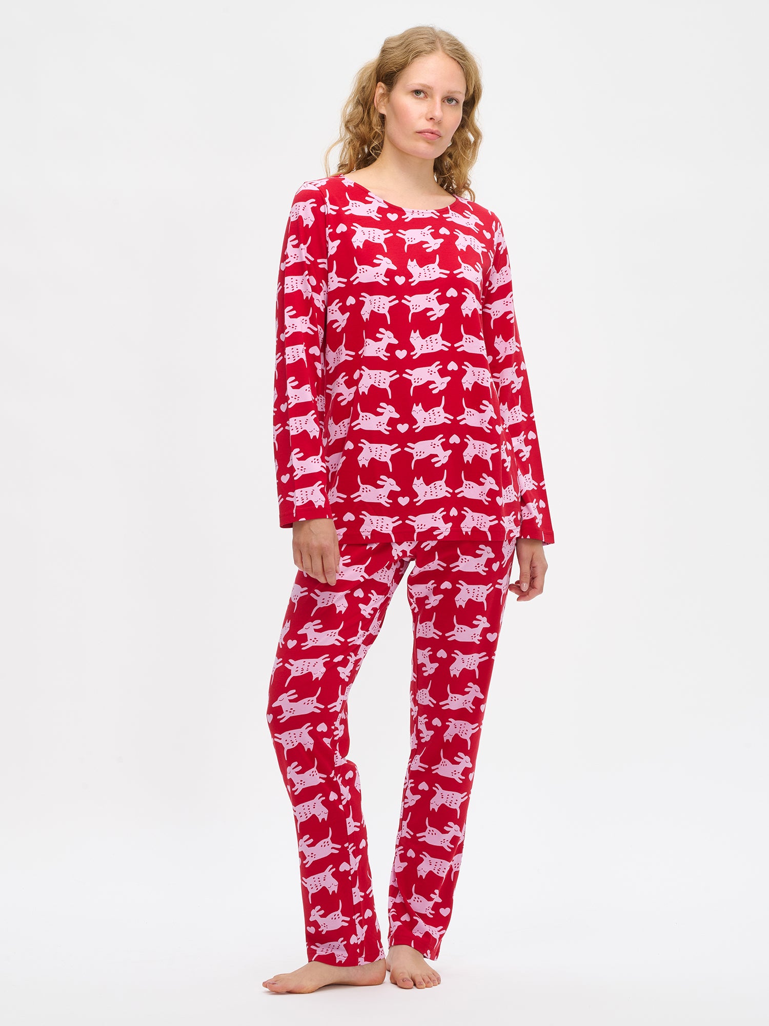 Nanson naisten punainen Kamu-pyjama, pitkähihainen paita ovaalilla pääntiellä ja suorat housut joustavalla vyötäröllä, mallin yllä kokokuvassa.