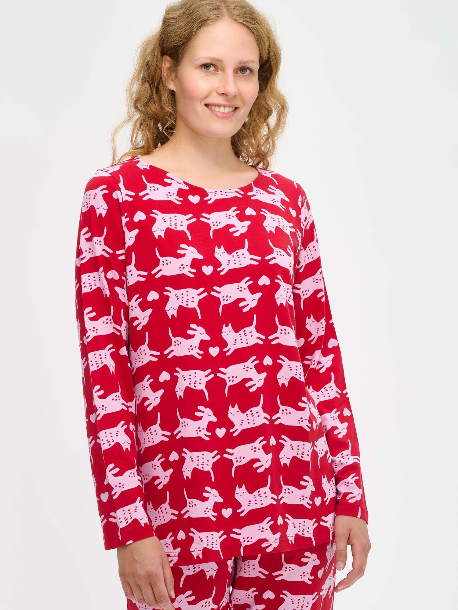 Nanson naisten punainen Kamu-pyjama, kuosillinen paita ja housut pehmeää puuvilla-modaalia, mallin yllä puolivartalokuvassa.