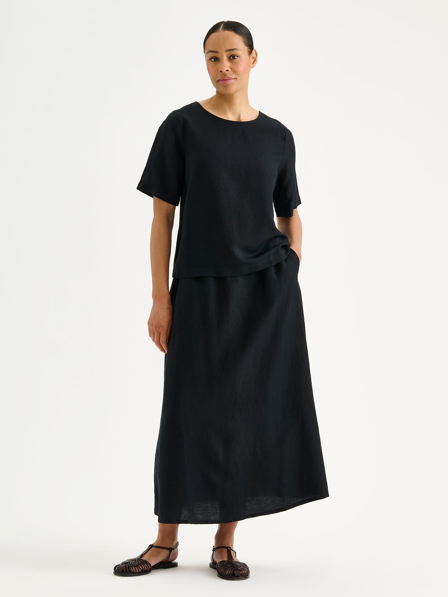 Nanson naisten musta ja mukavan rennon mallinen Irene-pusero mallin päällä mustan hameen kanssa