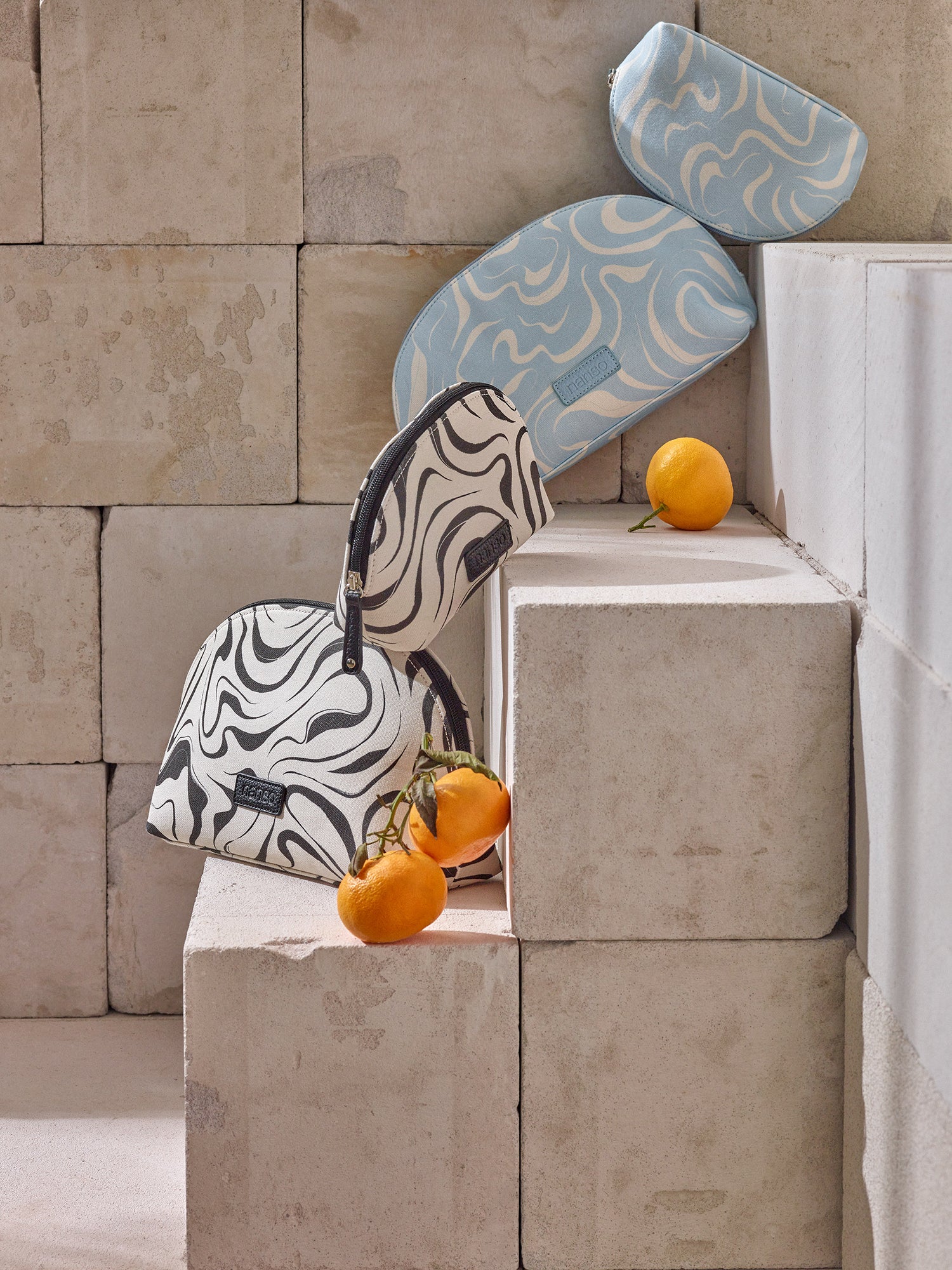 Nanson Vesi- kosmetiikkalaukut tuotekuvassa kauniissa asetelmassa hedelmien kanssa.