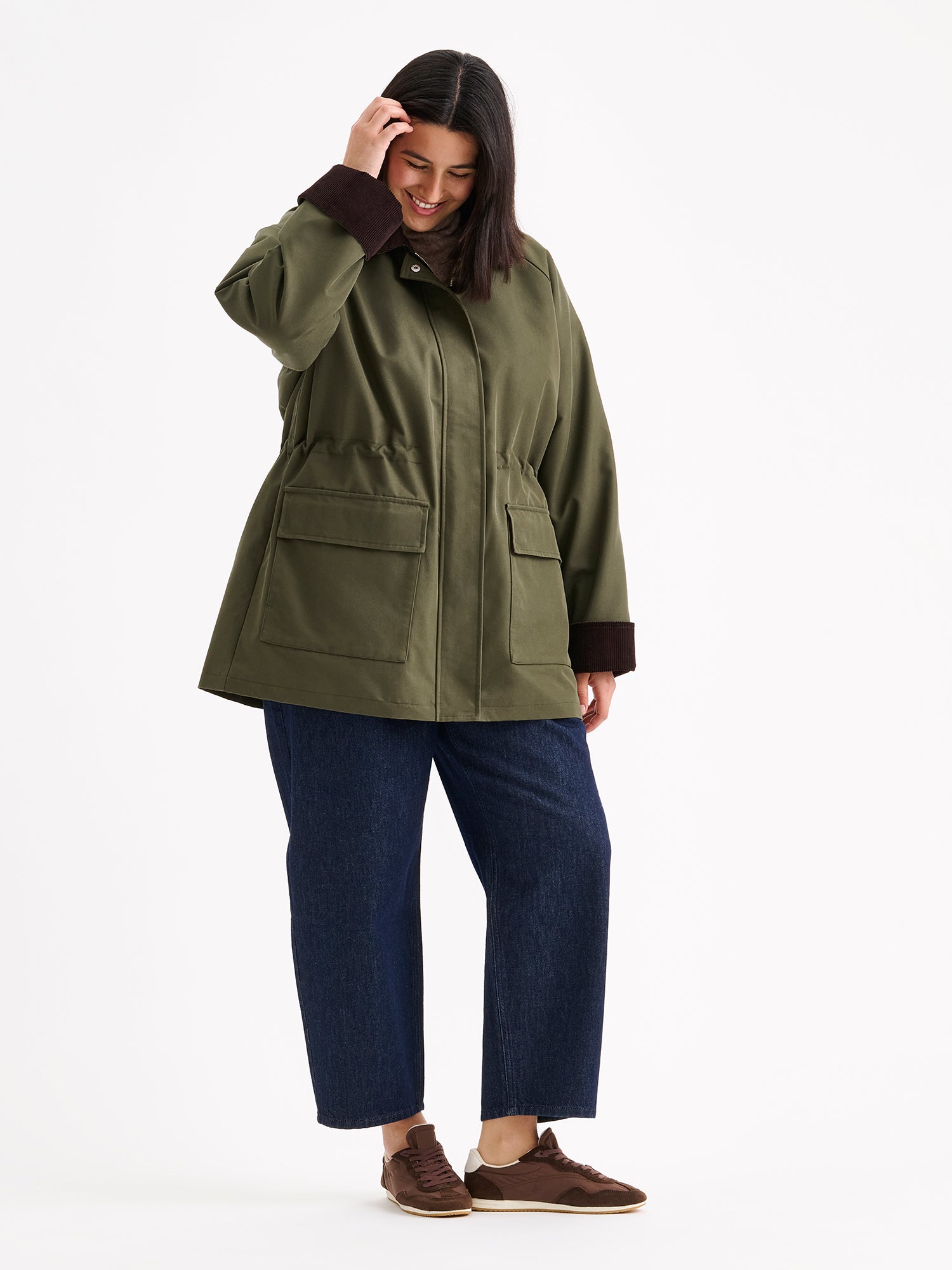 Rennon tyylikäs barn jacket - tyylinen vihreä Inna-parkatakki, mallin päällä farkkujen kanssa.