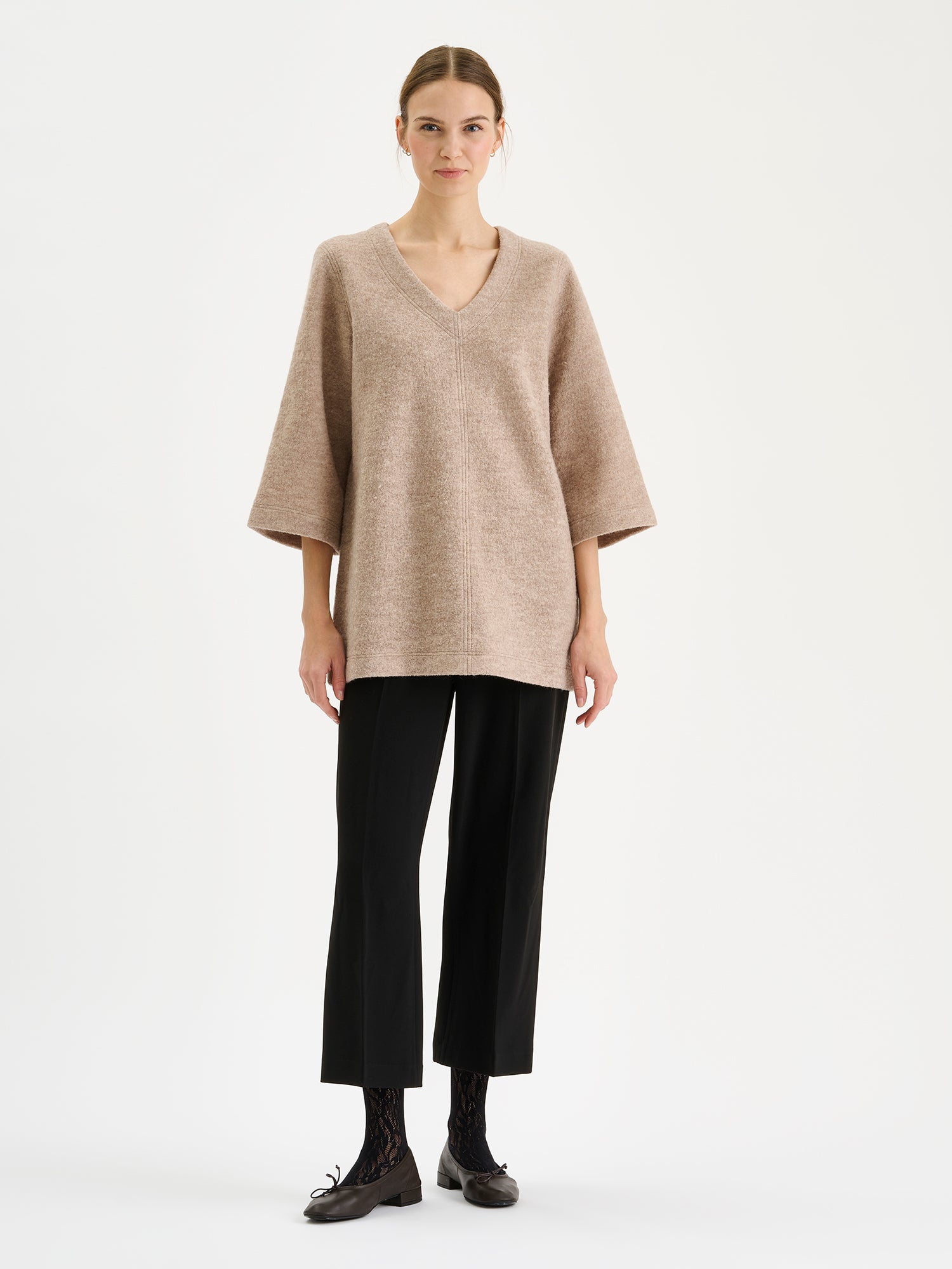 Nanson naisten rento ja tyylikäs beige Isabel-keittovillatunika mallin päällä mustien housujen kanssa.