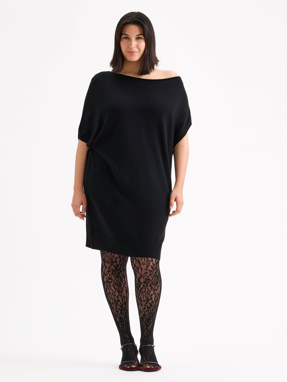 Naisten Villis-neulemekossa on näyttävä epäsymmetrinen siluetti, joka luo modernin ja elegantin ilmeen. Kuvassa mallin päällä pitsisukkahousujen kanssa. XL - 178cm