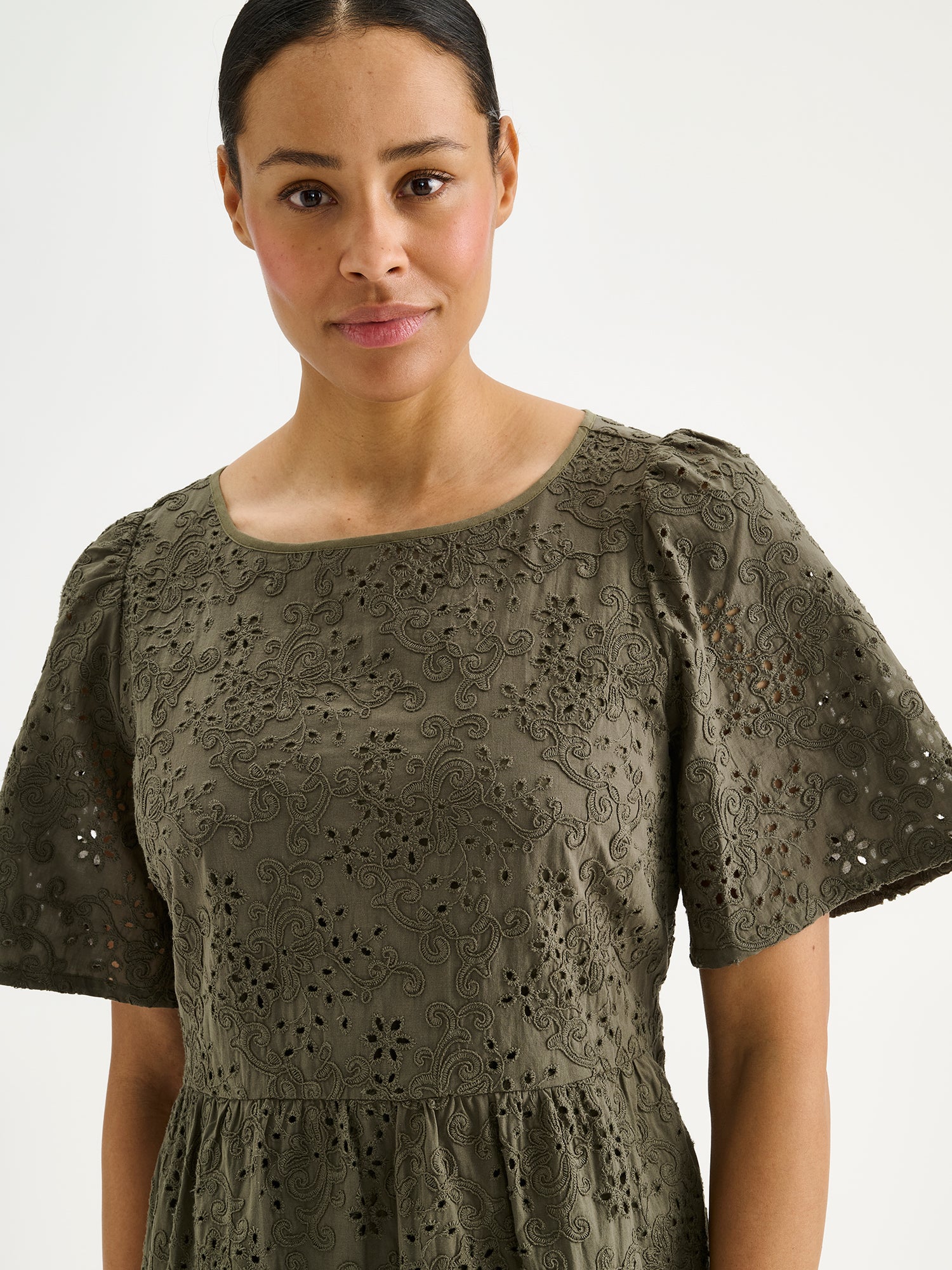 Nanson naisten kaunis pitkä oliivinvihreä Odette-mekko pitsimäisestä Broderie anglaise -tyyppisestä puuvillakankaasta mallin päällä lähikuvassa.