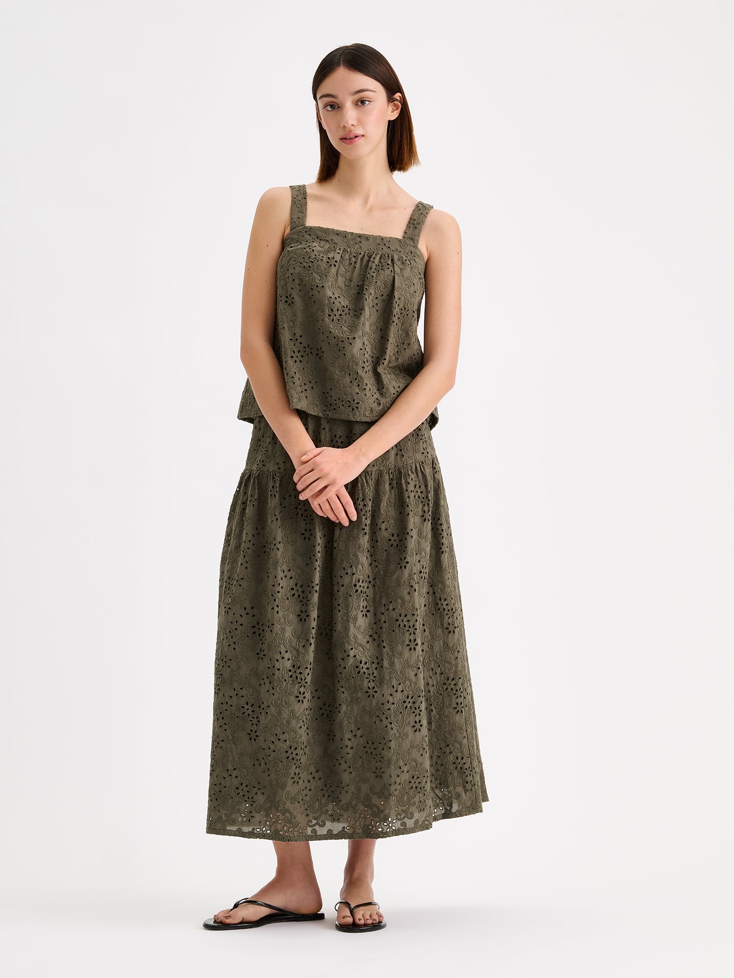Nanson kaunis maxi-pituinen ja leveähelmainen oliivinvihreä Odette-hame on valmistettu pitsimäisestä Broderie anglaise -tyyppisestä puuvillakankaasta, mallin päällä saman sarjan topin kanssa.
