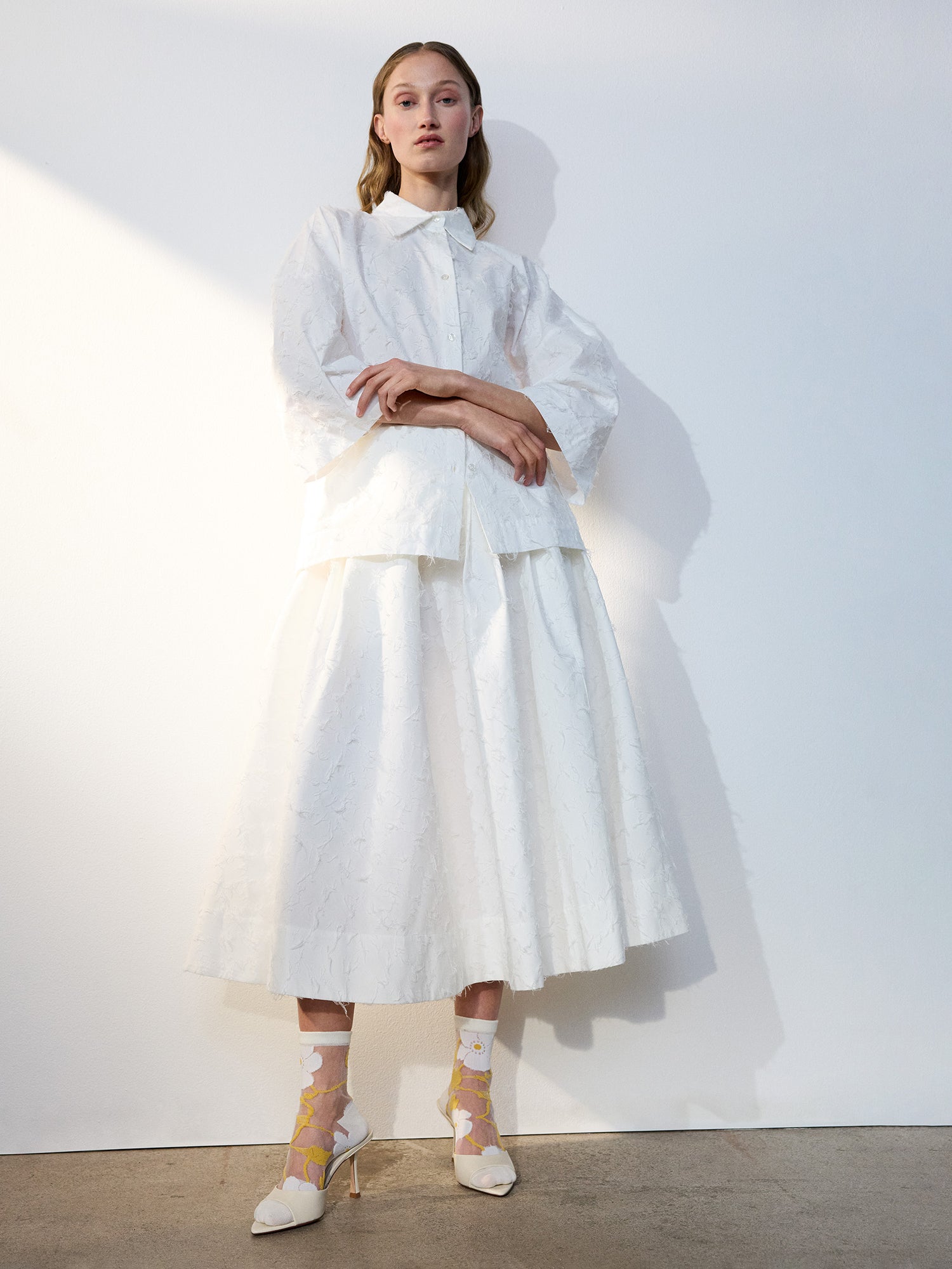 Voguen trendikkäät kukkakuosilliset läpikuultavat sukat herkällä värityksellä. Näillä sukilla kruunaat asusi ja tuot siihen kauniin yksityiskohdan. Kuvattuna mallin yllä midipituisen hameen ja korkokenkien kanssa.