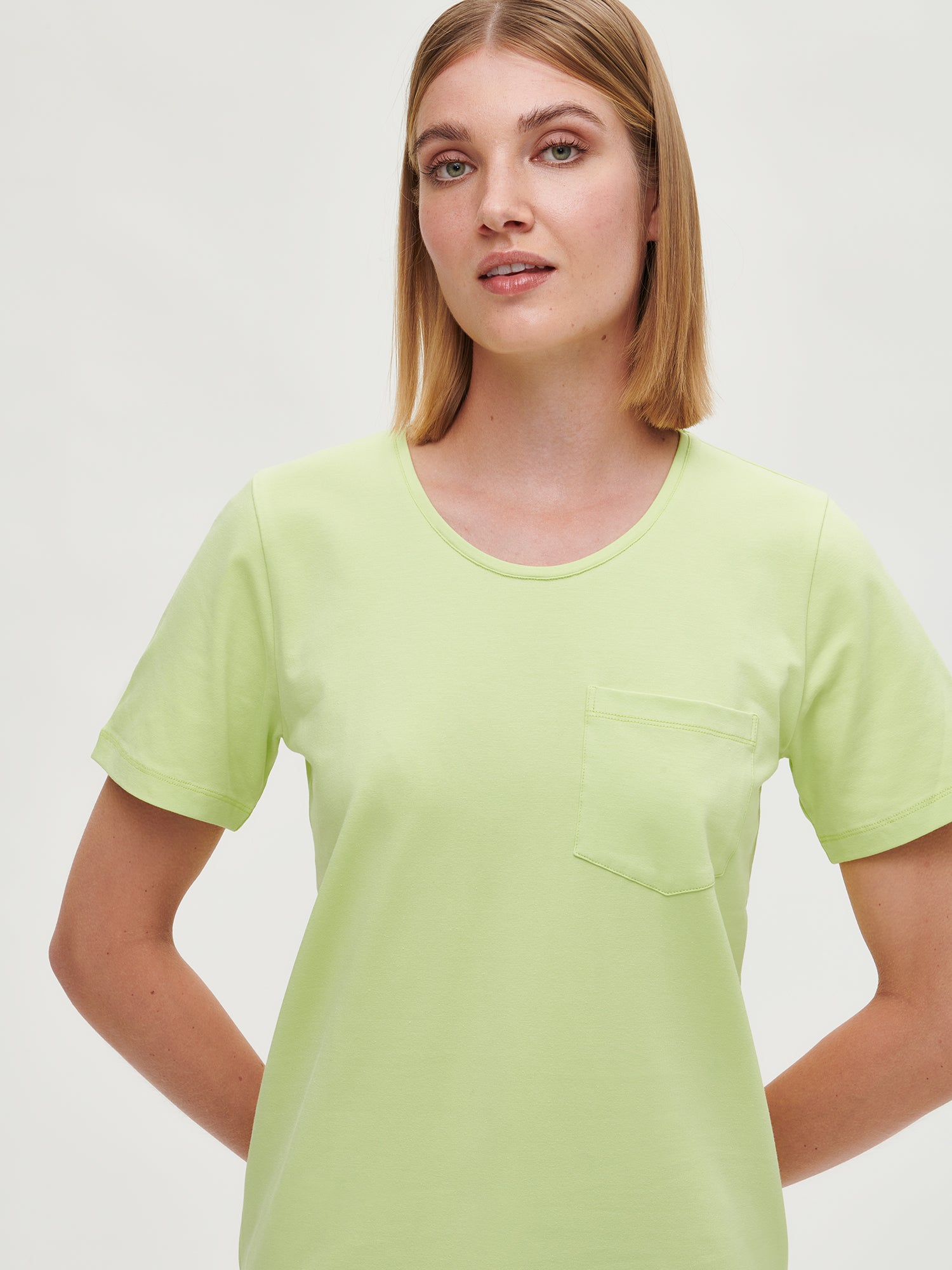 Nanson naisten limenvihreä Tasku-t-paita pyöreällä pääntiellä ja rintataskulla lähikuvassa mallin päällä edestä