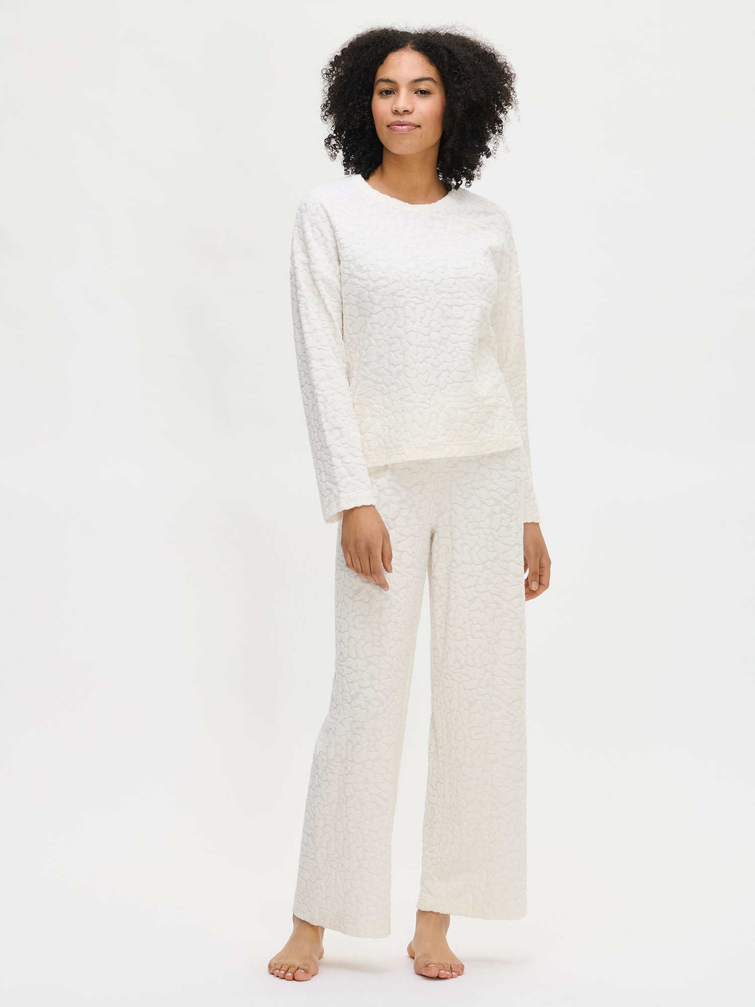 Nanson naisten valkoinen Gepardi-loungewear-paita ja housut mallin päällä edestä, rento asukokonaisuus.