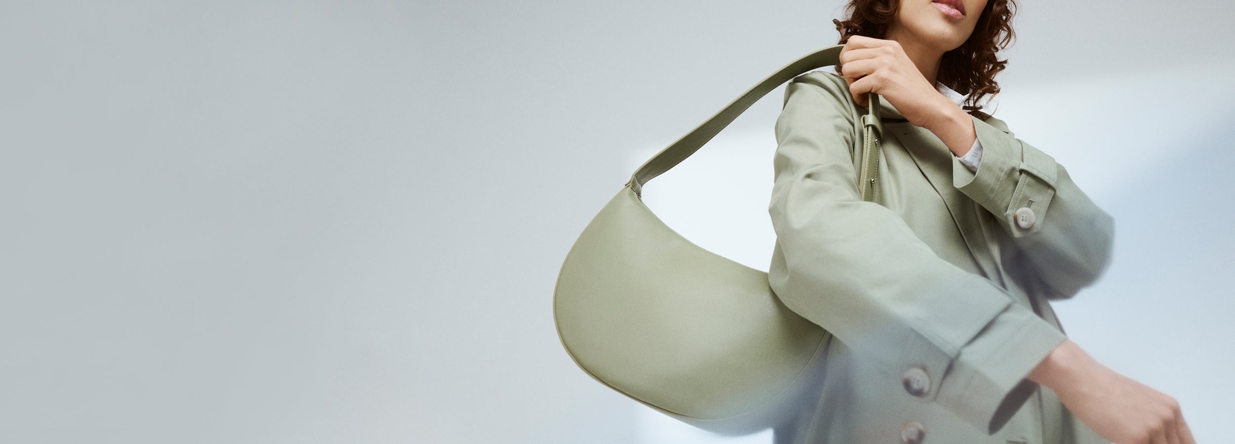 Nanson vaaleanvihreä Olka Kuu laukku mallin olalla trenssin kanssa