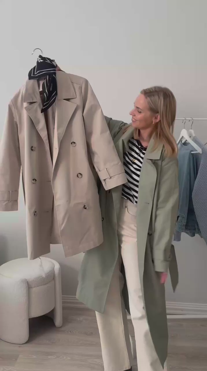 Videolla nainen esittelee useamman Nanso-asun kuten beigen Midi Trenssi-takn sekä vihreän Trenssi-takin.