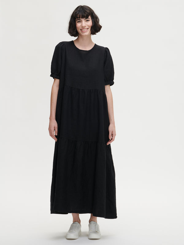 Nanson naisten kaunis musta Sarastus-mekko volyymisilla frillakerroksilla ja lyhyillä puhvihihoilla, joissa on napit säätövaralla. 